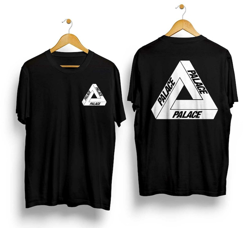 Puede incluir: Dos camisetas negras con la palabra "PALACE" en blanco, formando un dise&ntilde;o triangular. Una camiseta tiene el logo en el pecho, la otra en la espalda. Ambas cuelgan de perchas de madera.