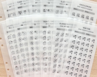 May include: A set of clear plastic budget planner inserts with printed labels and icons. Labels include "Car Maintenance," "Groceries," "Rent/Mortgage," and "Water." Each insert has sections for "Each" and "Total." The Blushing Hippo logo is visible.