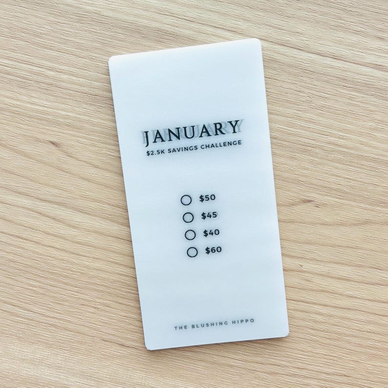 May include: A white card with the text "JANUARY $2.5K SAVINGS CHALLENGE" and a list of dollar amounts with radio buttons: $50, $45, $40, $60. The bottom of the card reads "THE BLUSHING HIPPO".