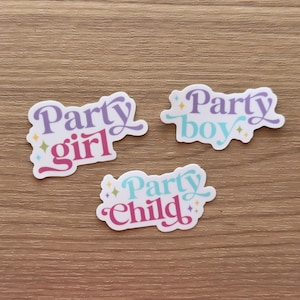 May include: Three die-cut stickers with white borders and small star accents. One sticker reads Party girl in purple and pink, one reads Party boy in purple and light blue, and one reads Party Child in light blue and pink with a decorative font.