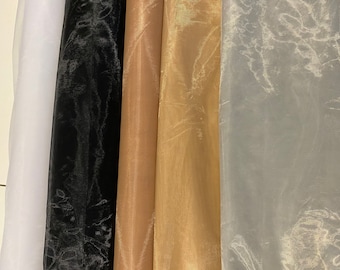 May include: Five rolls of sheer fabric in different colors: white, black, brown, gold, and gray. The fabric has a crinkled texture.