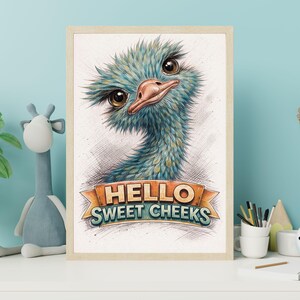 May include: A framed art print featuring a whimsical illustration of an ostrich with blue and teal feathers, a pink beak, and large brown eyes. The print includes the text "HELLO SWEET CHEEKS" on a banner.