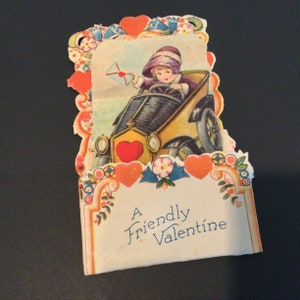 Vintage carte rétractable de la Saint-Valentin petite fille dans la voiture tenant une enveloppe avec un coeur. Éphémère livraison gratuite