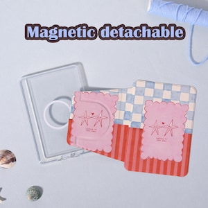 May include: A clear, magnetic detachable phone case with a pink and red patterned card. The card features two star illustrations and the text "counting my sweet stars". The background is light blue.