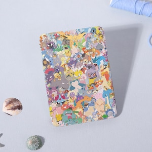 May include: A rectangular phone case featuring a colorful collage of various cartoon characters. The design includes a variety of colors, including blue, yellow, green, and purple. The case is likely made of a durable material to protect the phone.