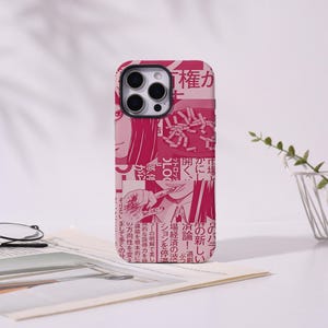 May include: A smartphone case featuring a collage of pink and white manga-style illustrations and Japanese text. The design includes close-up panels of a character's face and hand, layered over a background of printed Japanese newspaper columns.