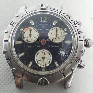 Könnte beinhalten: Eine Candino Yachting Split-Time-Uhr aus Edelstahl mit dunkelblauem Zifferblatt. Die Uhr verfügt über drei Hilfszifferblätter, ein Datumsfenster und Leuchtzeiger. Sie hat eine silberne Lünette mit schwarzen Markierungen.