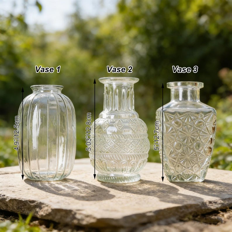 May include: Three clear glass vases of varying designs and sizes are displayed on a stone surface. The vases are labeled "Vase 1", "Vase 2", and "Vase 3". Vase 1 is 4.9 inches (12.5cm) tall, Vase 2 is 5.03 inches (12.8cm) tall, and Vase 3 is 5 inches (12.7cm) tall.