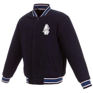 May include: Navy blue baseball-style jacket with a white and blue striped collar, cuffs, and hem. Features a white patch with a bear holding a baseball bat. The jacket has a button-up front and two front pockets.