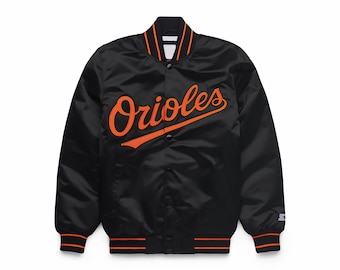 May include: Black satin baseball jacket featuring the word "Orioles" in orange script. The jacket has orange and white striped trim on the collar, cuffs, and hem. A classic sports apparel item.