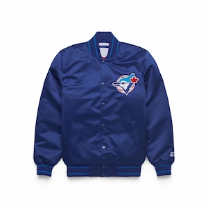 May include: A blue satin jacket with a snap-button closure. The jacket features a team logo patch on the chest and blue and white striped trim on the collar, cuffs, and hem. The jacket has two front pockets and a Starter logo on the sleeve.