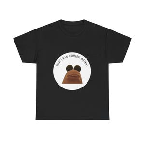 May include: Black t-shirt featuring a humorous design. A white circle contains a cartoonish image of a finger with googly eyes and a mouth. The text "THERE'S BEEN NUMEROUS INJURIES" is printed around the circle.