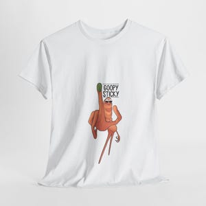 Pode incluir: Camiseta branca com uma ilustração de desenho animado de uma mão com um dedo verde usando óculos de sol. A mão segura uma placa com o texto "GOOPY STICKY" em preto. A camiseta é feita de um material macio.