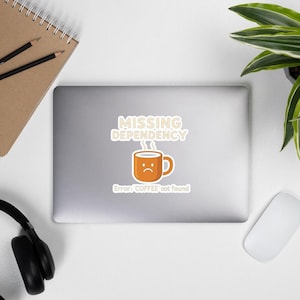 May include: A sticker with the text "MISSING DEPENDENCY" above a cartoon coffee mug with a sad face. Below the mug, the text reads "Error: COFFEE not found". The mug is orange with a white outline, and the text is in a sans-serif font.