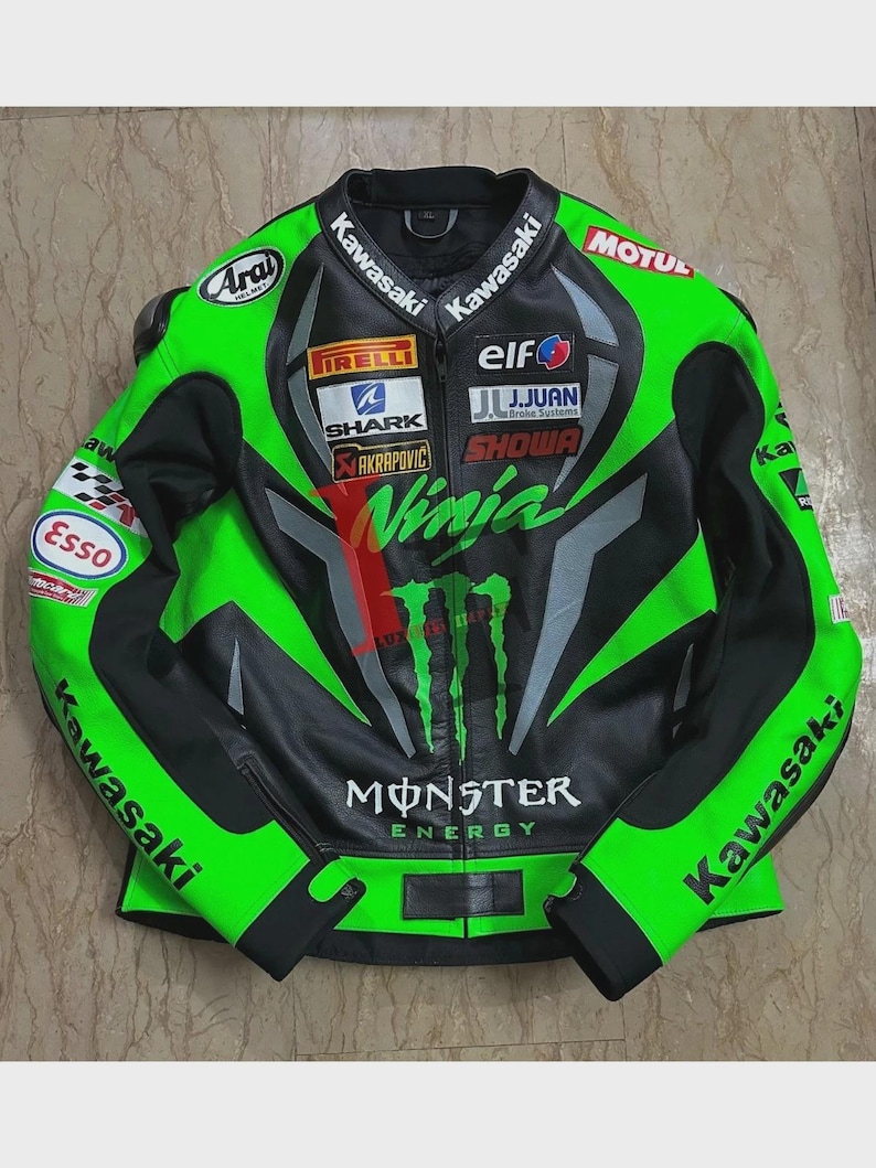 May include: A black and green Kawasaki Ninja motorcycle racing jacket. The jacket features multiple sponsor logos, including Monster Energy, Pirelli, and Elf. The jacket has a zip-up front and is made of leather.