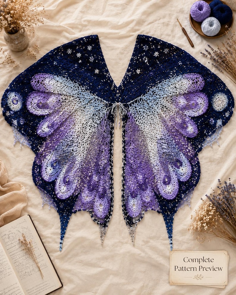 May include: A crochet shawl designed to resemble butterfly wings, featuring a gradient of dark navy blue, light blue, and purple yarn. The intricate lace pattern includes small star-shaped motifs and scalloped edges, with a card labeled Complete Pattern Preview.