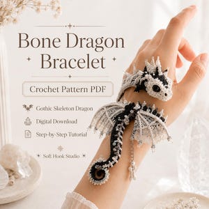 Op de afbeelding: Een gehaakte drakenarmband in een zwart-wit kleurenschema met gedetailleerde vleugels en staart. De tekst luidt: Bone Dragon Bracelet, Crochet Pattern PDF, Gothic Skeleton Dragon, Digital Download, Step-by-Step Tutorial, Soft Hook Studio.