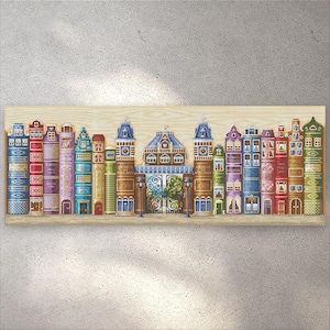 Puede incluir: Un panel decorativo de madera con un diseño caprichoso de edificios que se asemejan a libros. Los edificios están pintados en varios colores, incluyendo azul, rojo, morado y verde, con detalles intrincados. El panel está montado sobre una superficie de madera clara.