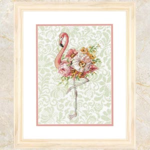 May include: Framed artwork featuring a pink flamingo with a bouquet of pink, white, and yellow flowers. The flamingo stands on one leg against a light green patterned background. The artwork is in a white frame.