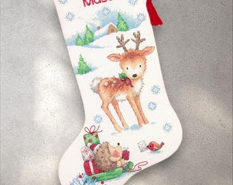 May include: White Christmas stocking with a deer and hedgehog design. The stocking features a winter scene with a deer, a hedgehog pulling gifts, and the name "Mason" in red. A red tassel hangs from the top.