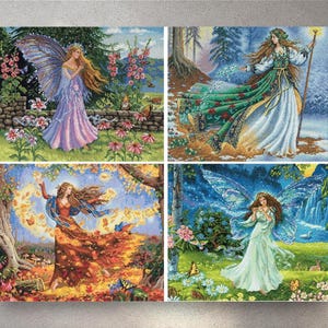 May include: Four cross-stitch panels showing fairies in various seasonal scenes. Each fairy has long hair and wings, wearing flowing gowns. The scenes include gardens, forests, and a winter landscape, with butterflies and flowers.