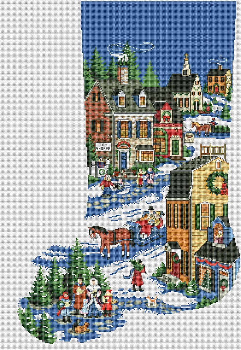 May include: A cross-stitch Christmas stocking featuring a winter village scene. The design includes houses, people, a horse-drawn sleigh, and the text "TOY SHOPPE" on a building. The color palette includes blue, red, green, and brown.