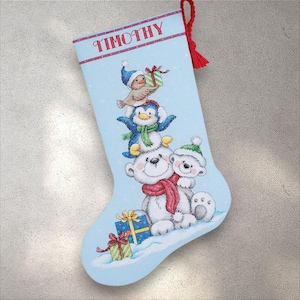 May include: Light blue Christmas stocking with the name "TIMOTHY" in red. The stocking features a stack of cartoon animals: a bird, a penguin, and two polar bears, with gifts and snow at the bottom. A red tassel hangs from the top.