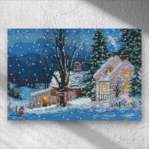 Può includere: Opera d'arte a punto croce raffigurante una scena invernale con una casa innevata, alberi e fiocchi di neve che cadono. La casa ha finestre illuminate, che suggeriscono calore. Un piccolo animale rosso è in primo piano. La tavolozza dei colori è dominata da blu, bianchi e tocchi di rosso.