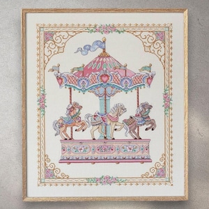 Puede incluir: Obra de arte de punto de cruz de un carrusel con tres caballos. El carrusel tiene un dosel rosa y azul y decoraciones florales. La obra de arte está enmarcada en un marco de madera clara y tiene un borde decorativo.
