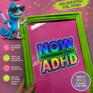 Puede incluir: Un marco de fotos verde brillante que contiene una impresión de lámina holográfica con el texto NOW THAT'S WHAT I CALL ADHD. Un camaleón azul de dibujos animados con gafas de sol está situado a la izquierda del marco, sosteniendo un tubo de lámina holográfica.