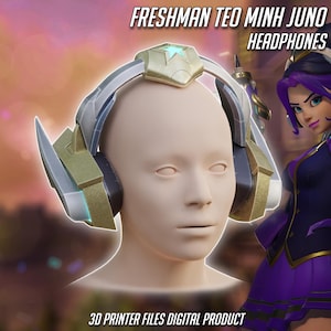 Op de afbeelding: Gedetailleerde afbeelding van een koptelefoon met een goud en zilver ontwerp, rustend op een mannequinhoofd. De tekst "FRESHMAN TEO MINH JUNO HEADPHONES" staat bovenaan en "3D PRINTER FILES DIGITAL PRODUCT" onderaan.