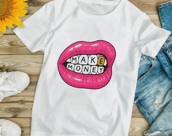 Könnte beinhalten: Weißes T-Shirt mit einer Grafik von rosa Lippen und den Worten "MAKE MONEY" in Schwarz und Gold. Das T-Shirt besteht aus einem weichen Material und eignet sich für den lässigen Gebrauch. Das Design ist auffällig.