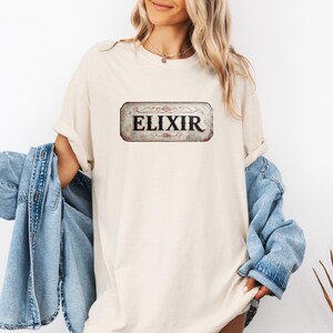 Vintage Elixir Sign T-Shirt, Retro Alchemy Inspired Tee, Old Apothecary Style Graphic Shirt for Magic Mystery and Potion Lovers, Comfort Tee