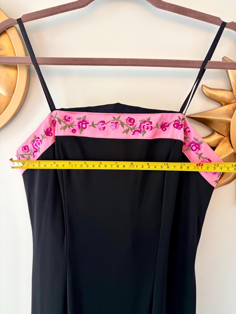 Puede incluir: Vestido negro con tirantes finos y una banda rosa en la parte superior. La banda rosa est&aacute; bordada con flores rosas y vides verdes. El vestido mide aproximadamente 35,5 cm en la parte superior.