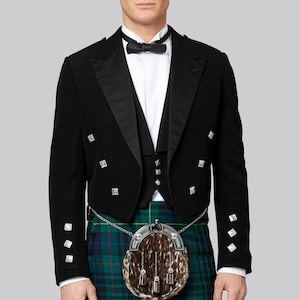 Puede incluir: Chaqueta negra formal con botones plateados y chaleco a juego. El atuendo incluye un kilt a cuadros verdes y azules y un sporran marrón y blanco. Una pajarita negra y una camisa blanca completan el conjunto.