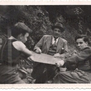 Foto francese - Uomo e ragazzi seduti fuori a un tavolo