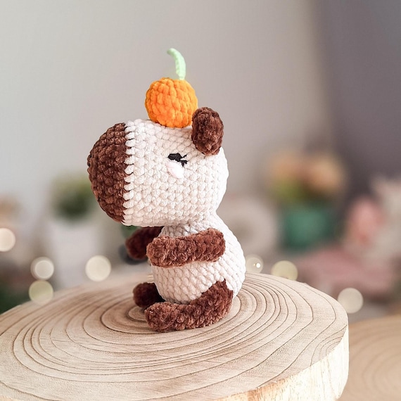 A handmade crochet capybara — the internet's most beloved chill animal — complete with its iconic tangerine accessory, made by an actual human with yarn.