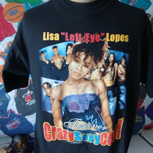 May include: Black t-shirt with a colorful image of Lisa "Left-Eye" Lopes from the group TLC. The image includes the text "Forever Crazy Sexy Cool".