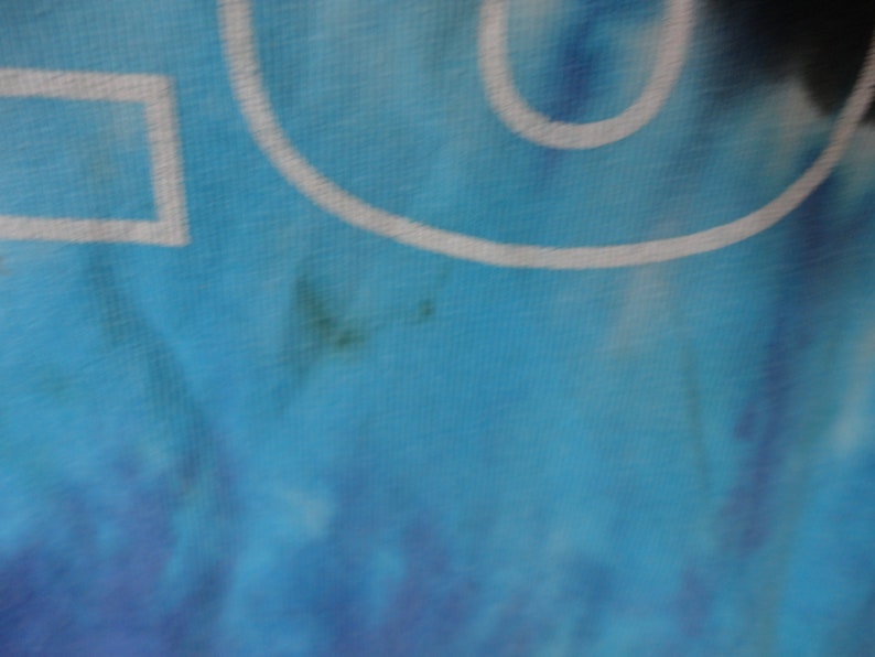 May include: A blue and white tie-dye fabric with a white outline of a circle and a square.