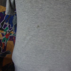 Peut inclure: Un t-shirt gris avec une surface lisse et textur&eacute;e. Le t-shirt est fait d'un tissu doux et confortable.