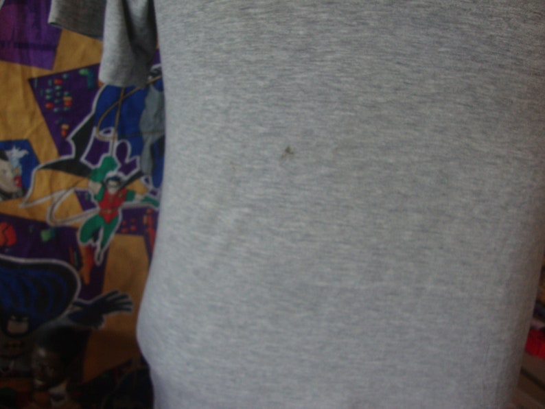Peut inclure: Un t-shirt gris avec une surface lisse et textur&eacute;e. Le t-shirt est fait d'un tissu doux et confortable.