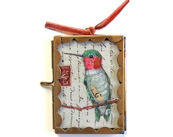 Cuadro de un pequeño colibrí: Papel y tela antiguos en un marco de cristal artesanal.