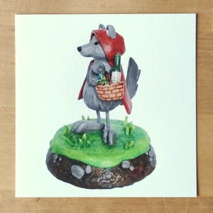 Peut inclure: Une sculpture fantaisiste d'un loup déguisé en Petit Chaperon rouge. Le loup porte un capuchon et une cape rouges, tenant un panier avec une bouteille et des fleurs. Il se tient sur une base herbeuse verte avec une bordure marron.