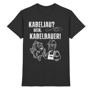 May include: Black t-shirt with a white graphic. The graphic features a cartoon fish and an electrician with the text "KABELJAU? NEIN, KABELBAUER!" above them. The electrician is holding tools and a cable.