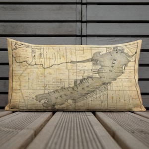 May include: A vintage map of Delavan, Wisconsin, featuring Lake Delavan and surrounding areas. The map is printed on a cream-colored background with black ink and includes street names and landmarks.