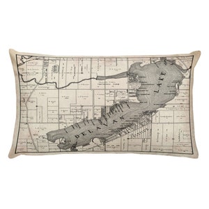 May include: A vintage map of Delavan, Wisconsin, featuring a detailed illustration of the city's streets, buildings, and Lake Delavan. The map is printed on a beige background with black ink.