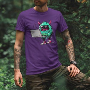 Peut inclure: T-shirt violet avec un monstre vert portant des lunettes de soleil et tenant un ordinateur portable. Le monstre a des cornes et coule de la goo verte.