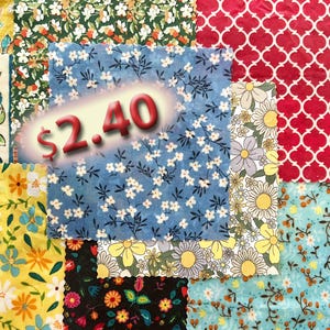 May include: A patchwork of fabric swatches in various floral and geometric patterns. The fabrics feature a range of colors, including blue, red, yellow, and green. The price tag shows "$2.40".