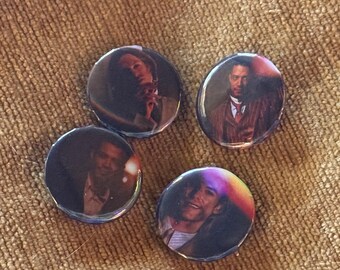 May include: Four circular pin-back buttons featuring photographic portraits of individuals. Each button displays a distinct person in a formal or semi-formal setting, with varying lighting conditions and color tones across the four separate circular designs.