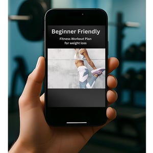 Puede incluir: Un teléfono inteligente muestra un plan de entrenamiento físico para perder peso, con el texto "Beginner Friendly". La pantalla muestra a una mujer con ropa deportiva estirándose. El teléfono se sostiene en una mano, con un fondo borroso de gimnasio.